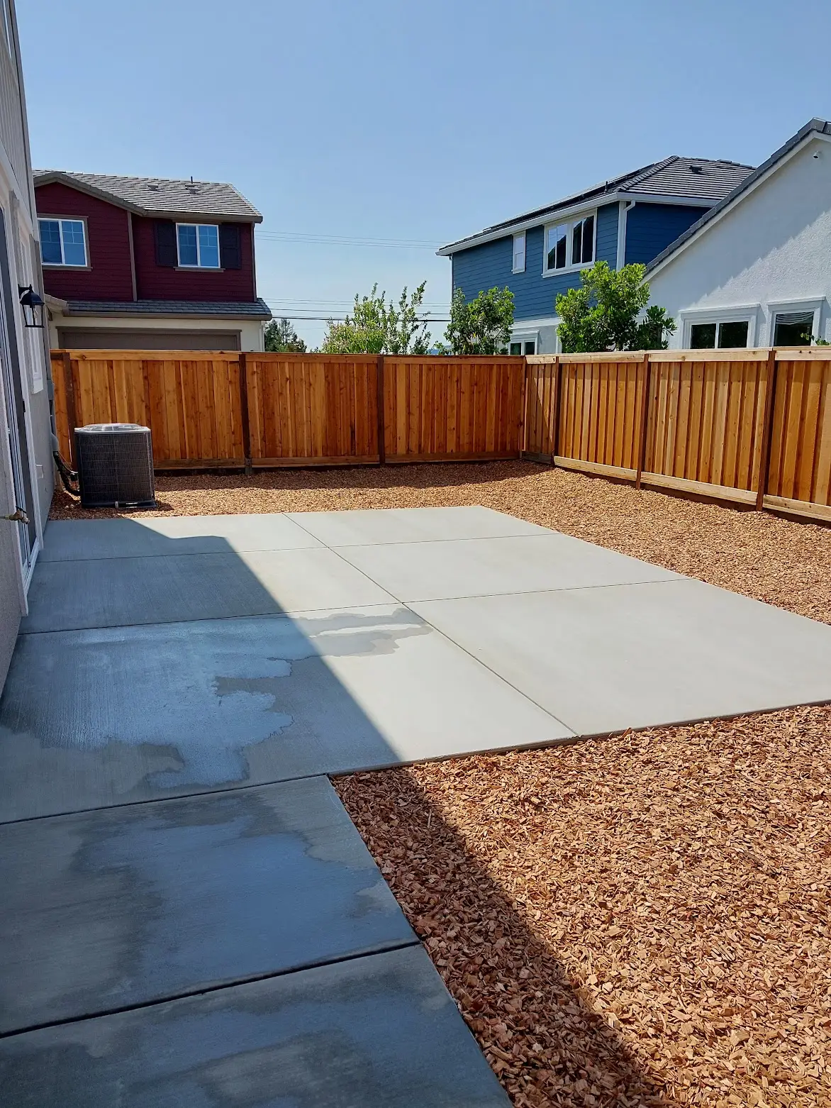 clean concrete walkway and backyard landscaping